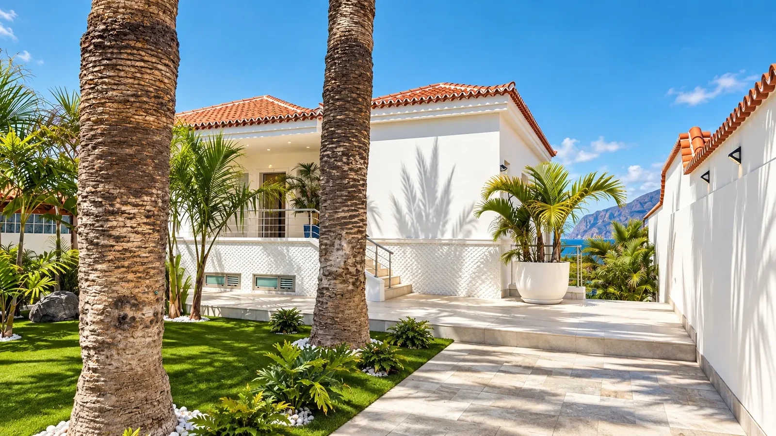 White villa facade, palm trees and tiled terrace at Villa White Octopus in Puerto de Santiago