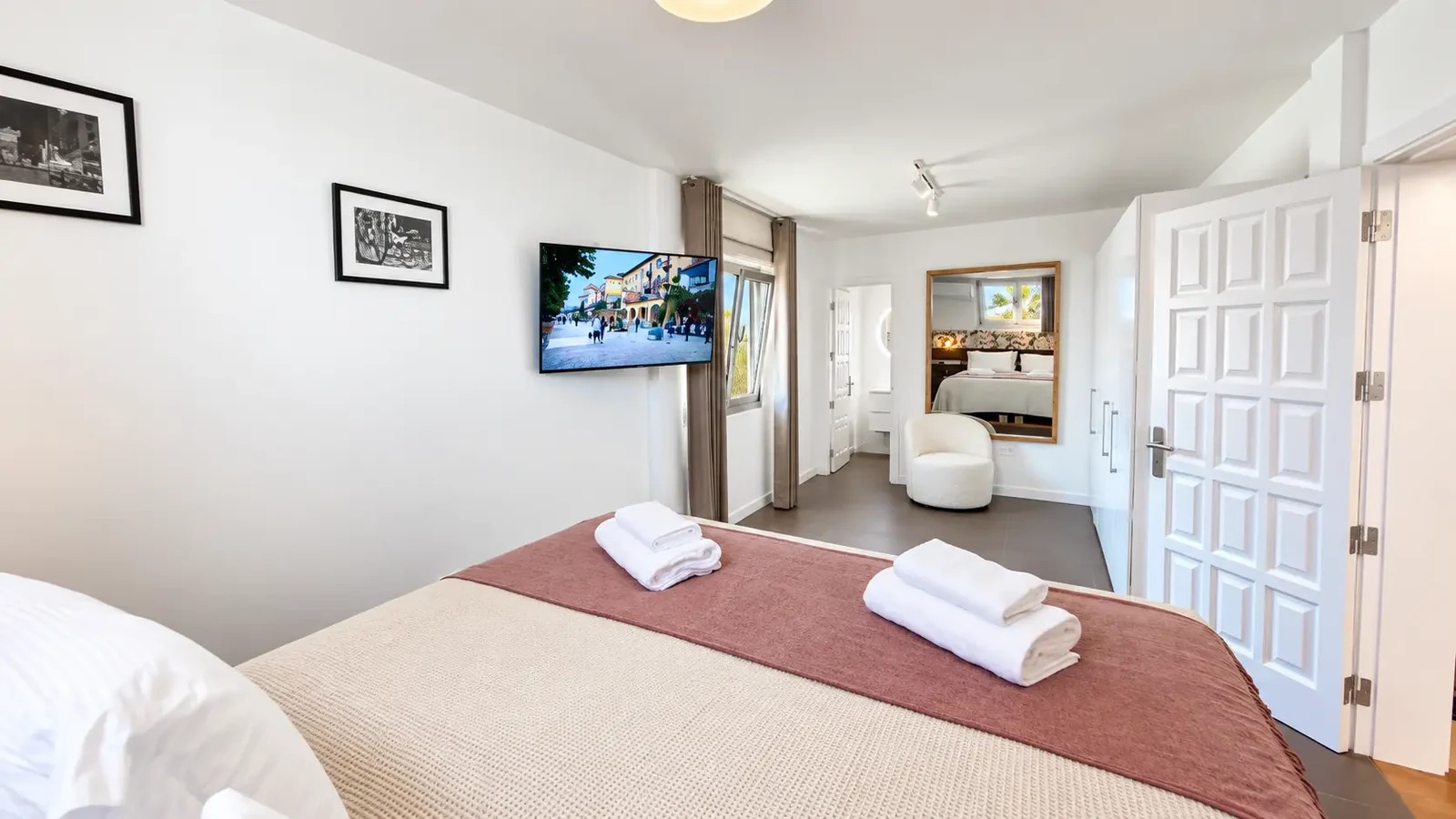 Bedroom with television and adjoining lounge space at Villa White Octopus