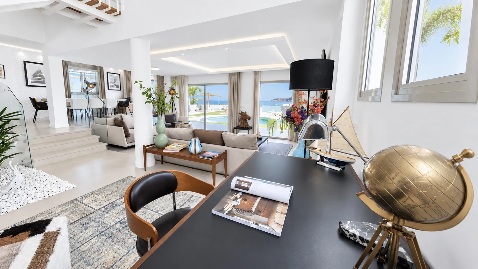 Living space with desk, staircase and ocean view at Villa White Octopus