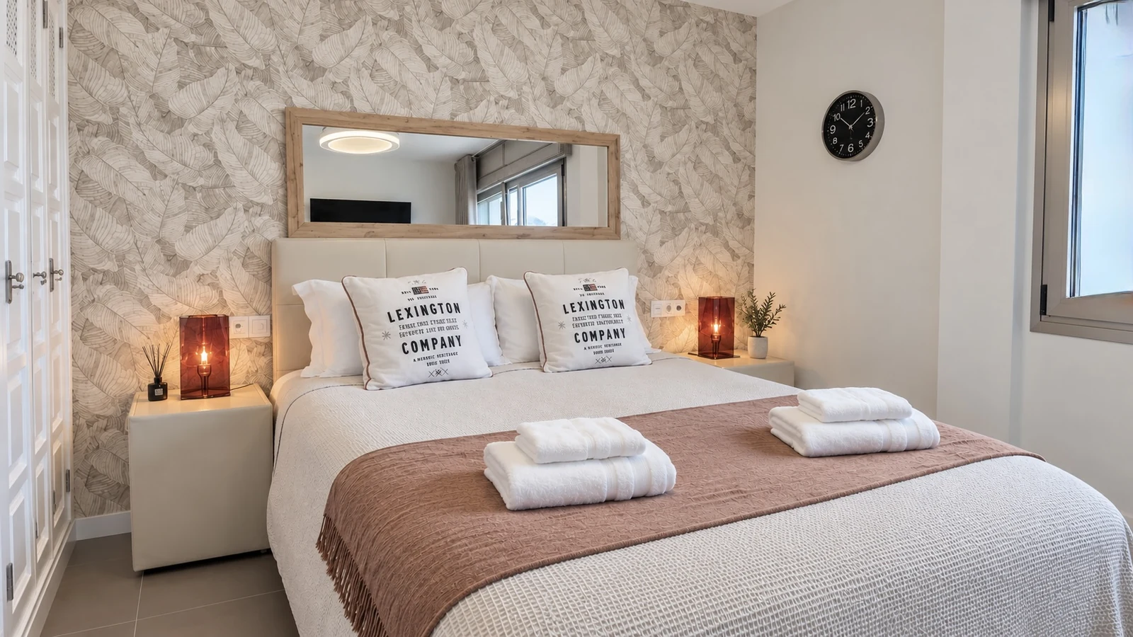 Bedroom with patterned wallpaper and prepared towels at Villa White Octopus
