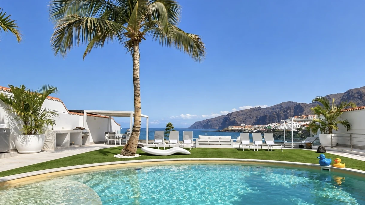 Pool edge, palm tree and Los Gigantes cliffs seen from Villa White Octopus, Tenerife