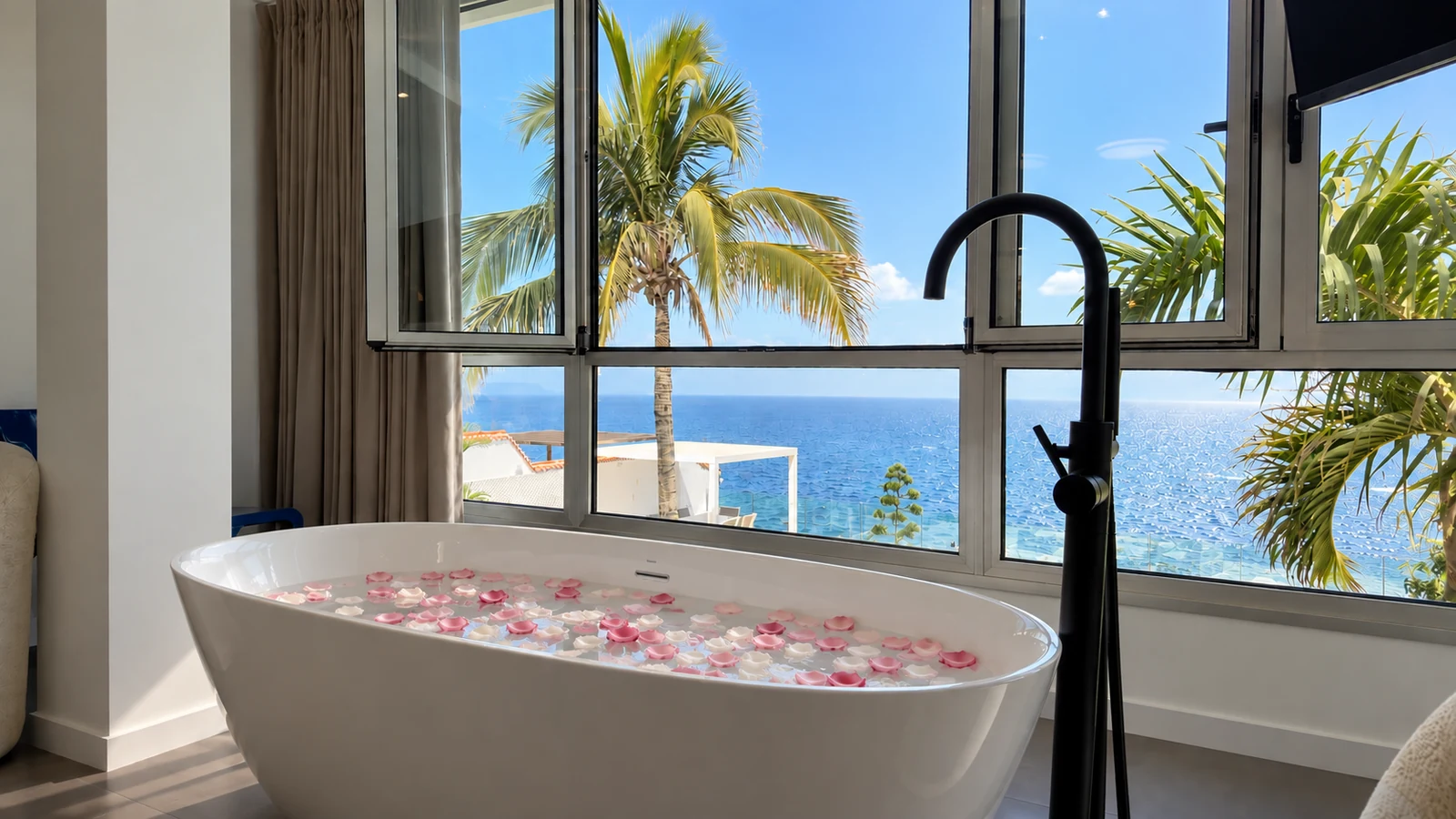 Freestanding bath tub with rose petals and sea view at Villa White Octopus